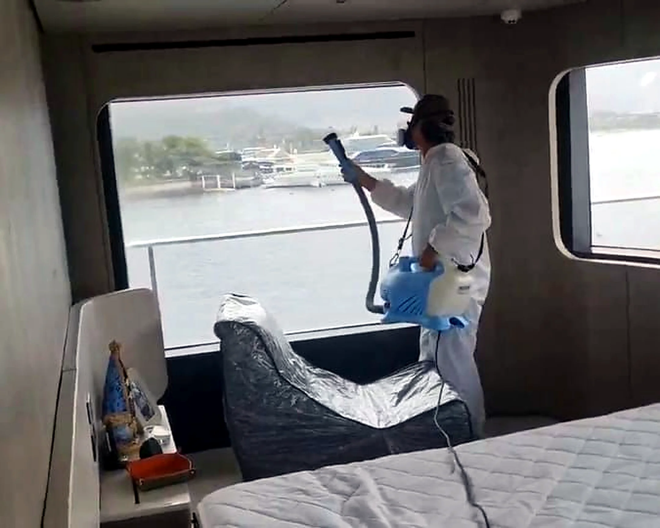 Tecnico aplicando produto especializado em quarto de embarcacao